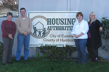 A group of individuals standing next to a Housing Authority sign