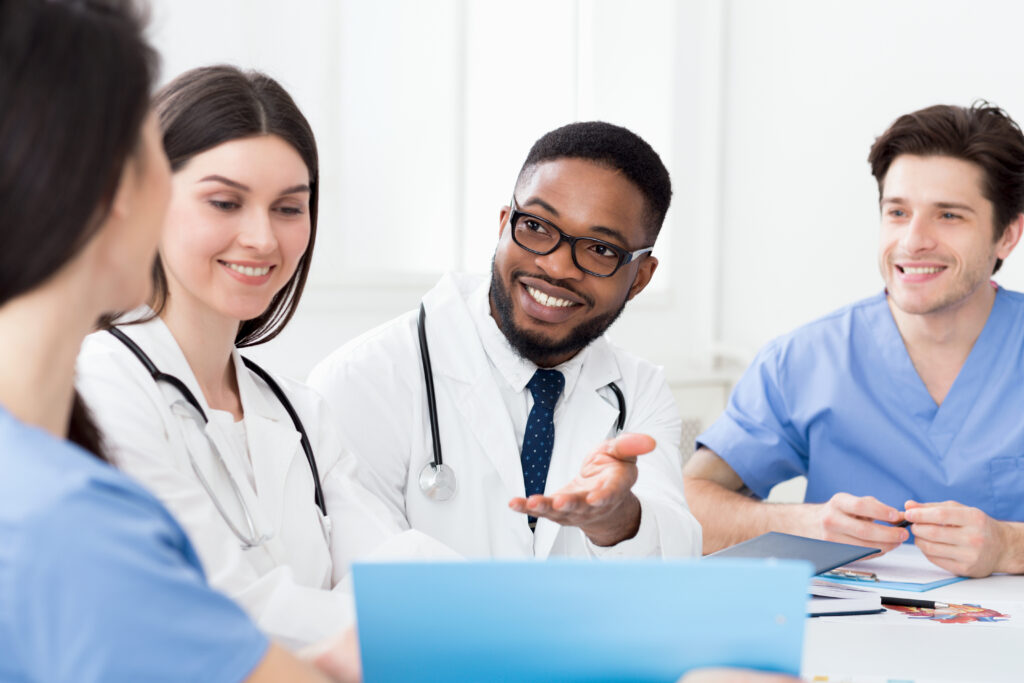 Multiracial medical team having meeting with doctor, discussing patients records